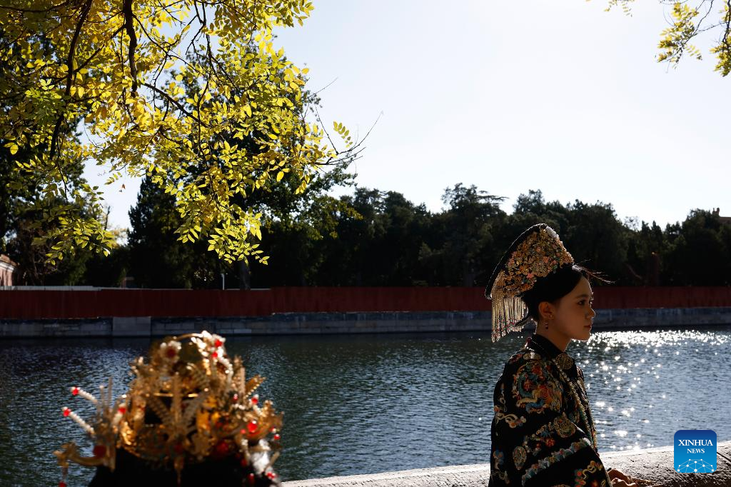 Tourists in traditional Chinese costumes take photos at Palace Museum in Beijing