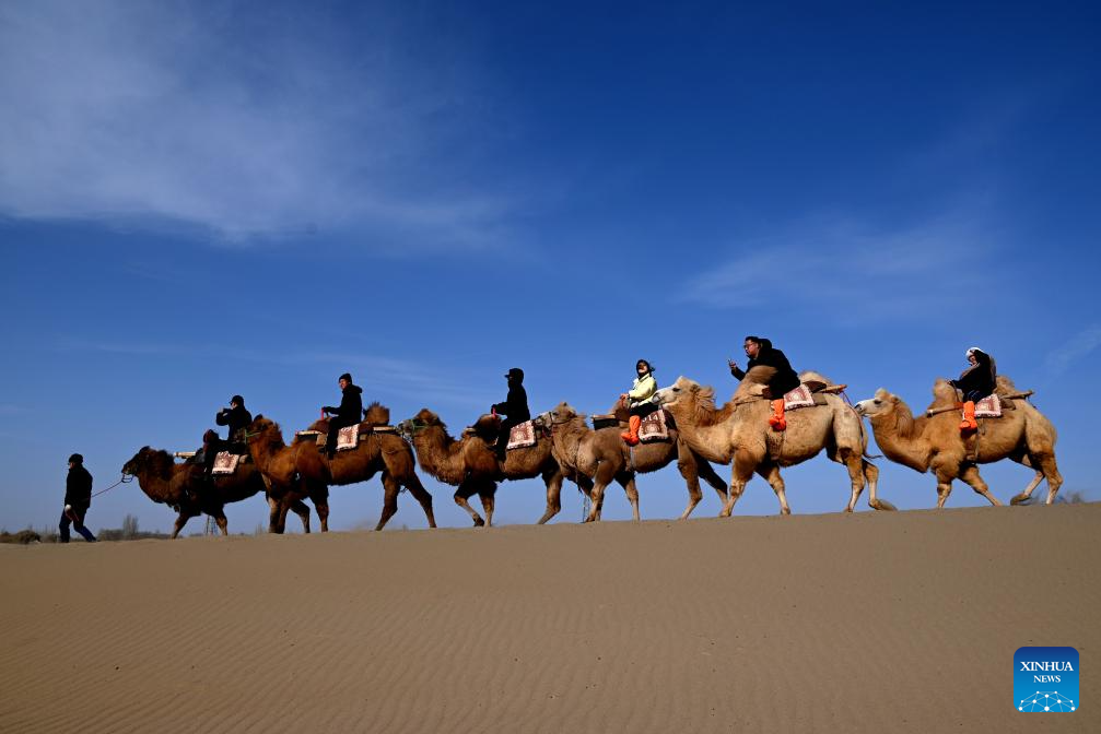 Tourists visit Mingsha Mountain, Crescent Spring Scenic Area in Dunhuang, China's Gansu